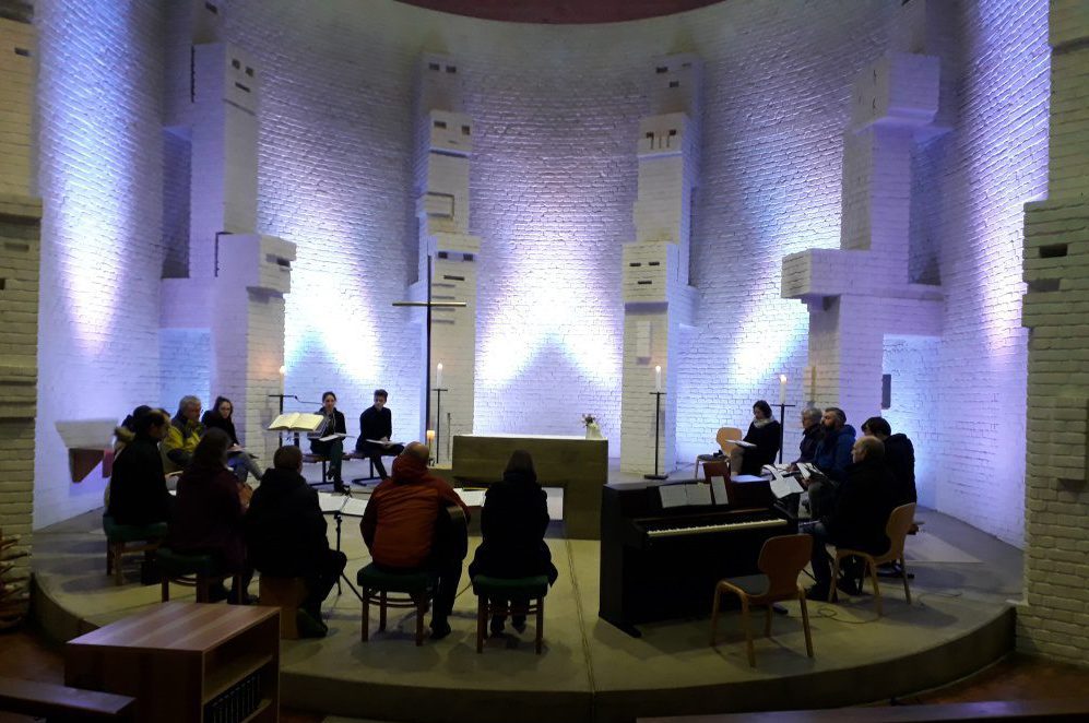 Gemeindes versammelt sich im Altarraum mit Liedern und Instrumenten.